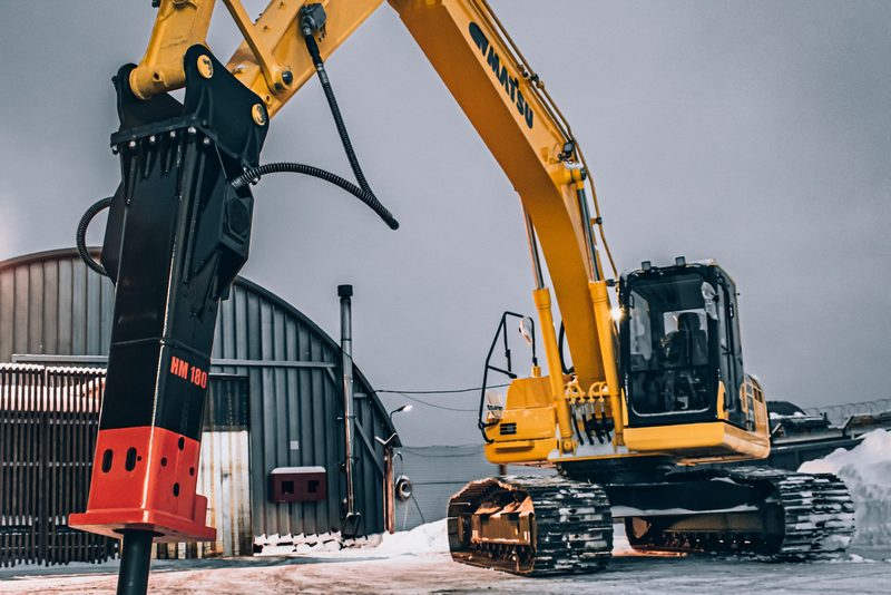 Hydraulické bourací kladivo na minibagru rozbíjí betonovou plochu