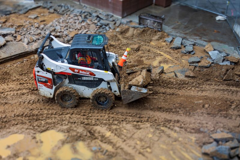 Smykový nakladač Bobcat nakládá suť na staveništi
